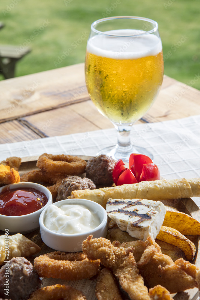 Fresh beer snacks assortment on wooden board Fresh beer snacks assortment on wooden board