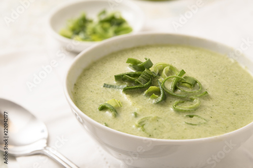 leek cream soup in a bowl on a white tablecloth