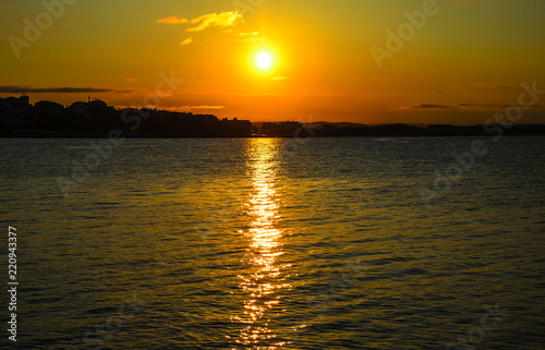 Sunset on the coast. On the horizon you can see the outlines of the city.