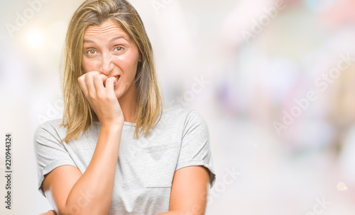 Young beautiful woman over isolated background looking stressed and nervous with hands on mouth biting nails. Anxiety problem.