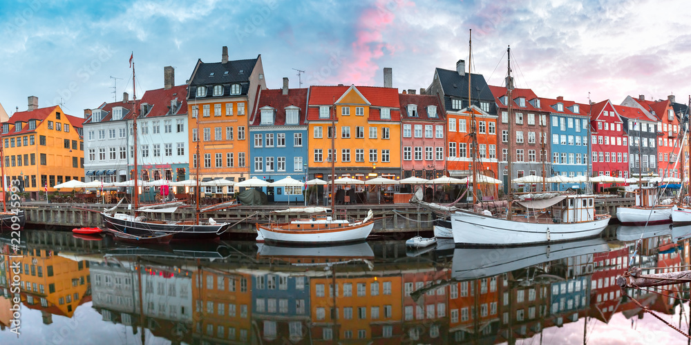 Obraz premium Nyhavn at sunrise, with colorful facades of old houses and old ships in the Old Town of Copenhagen, capital of Denmark.