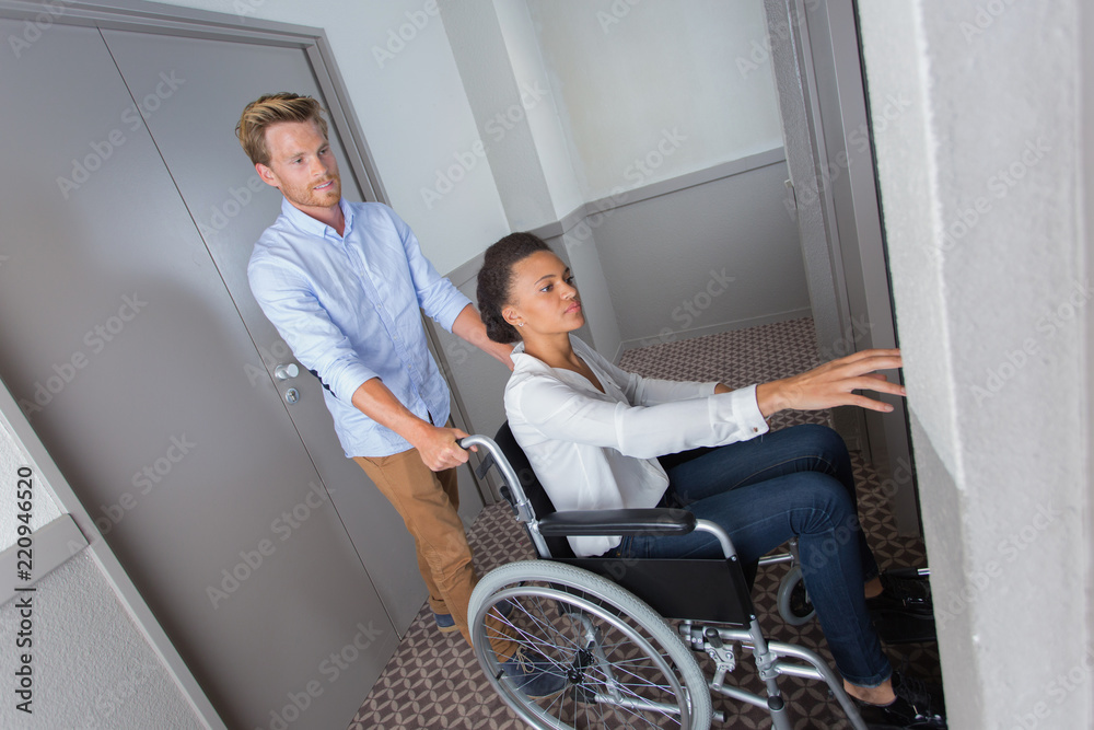 disabled woman on a wheelchair pushed by her boyfriend disabled woman on a wheelchair pushed by her boyfriend