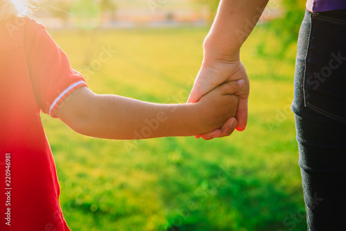 mother and child holding hands at sunset, parenting