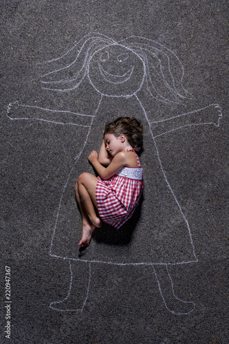 Photos A girl lies down inside a drawing that represents a mom