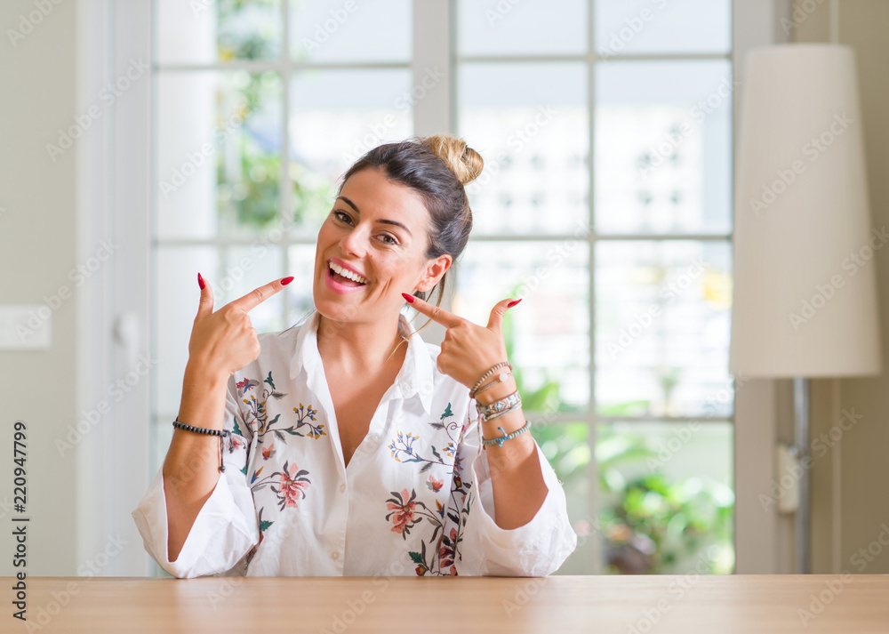 Young woman at home smiling confident showing and pointing with fingers teeth and mouth. Health concept. Young woman at home smiling confident showing and pointing with fingers teeth and mouth. Health concept.