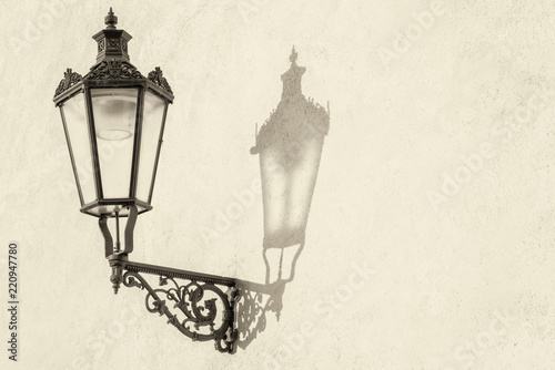 Old lantern on the city wall with shadow, retro vintage background