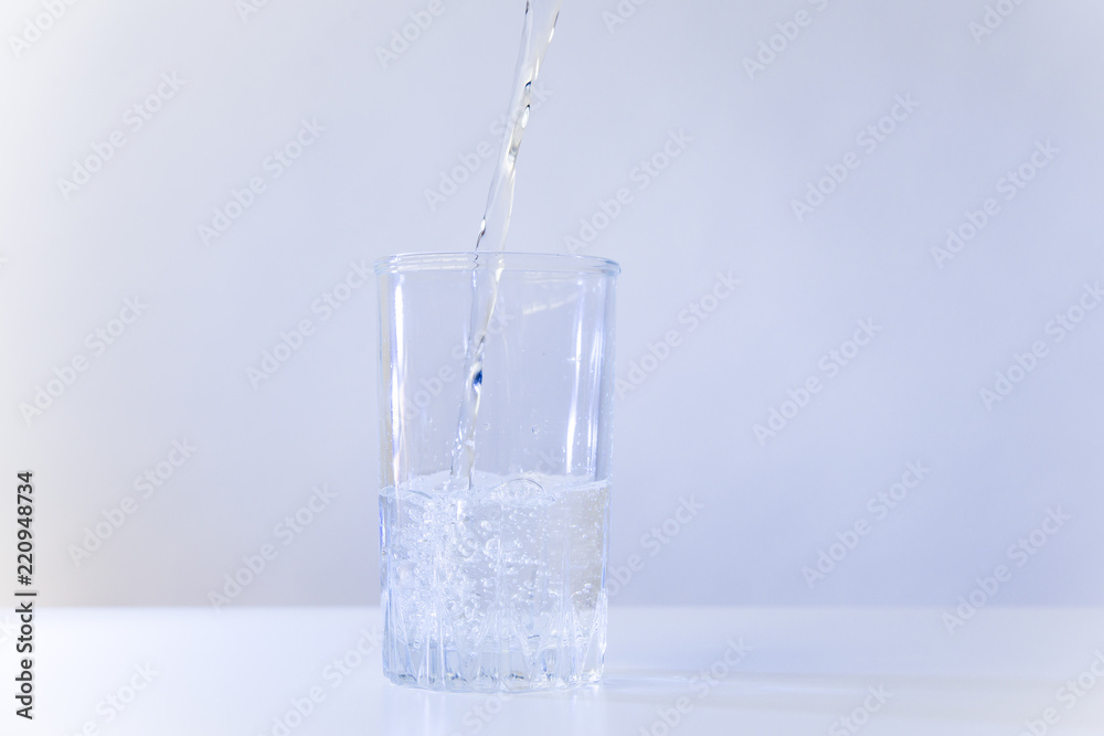Glass of pure water on a white kitchen table Glass of pure water on a white kitchen table