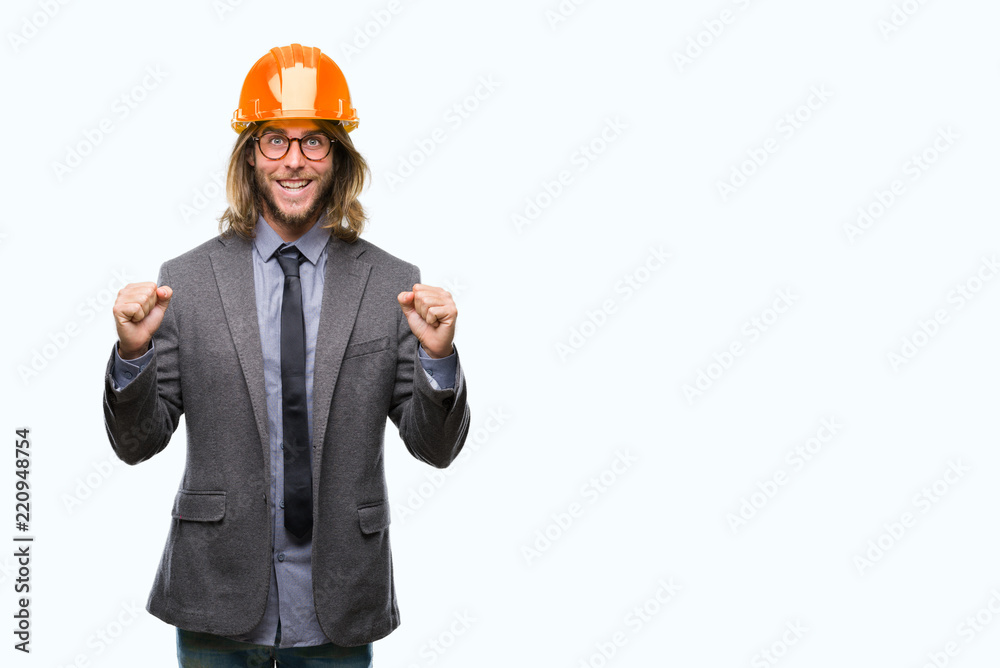 Young handsome architec man with long hair wearing safety helmet over isolated background celebrating surprised and amazed for success with arms raised and open eyes. Winner concept. Young handsome architec man with long hair wearing safety helmet over isolated background celebrating surprised and amazed for success with arms raised and open eyes. Winner concept.