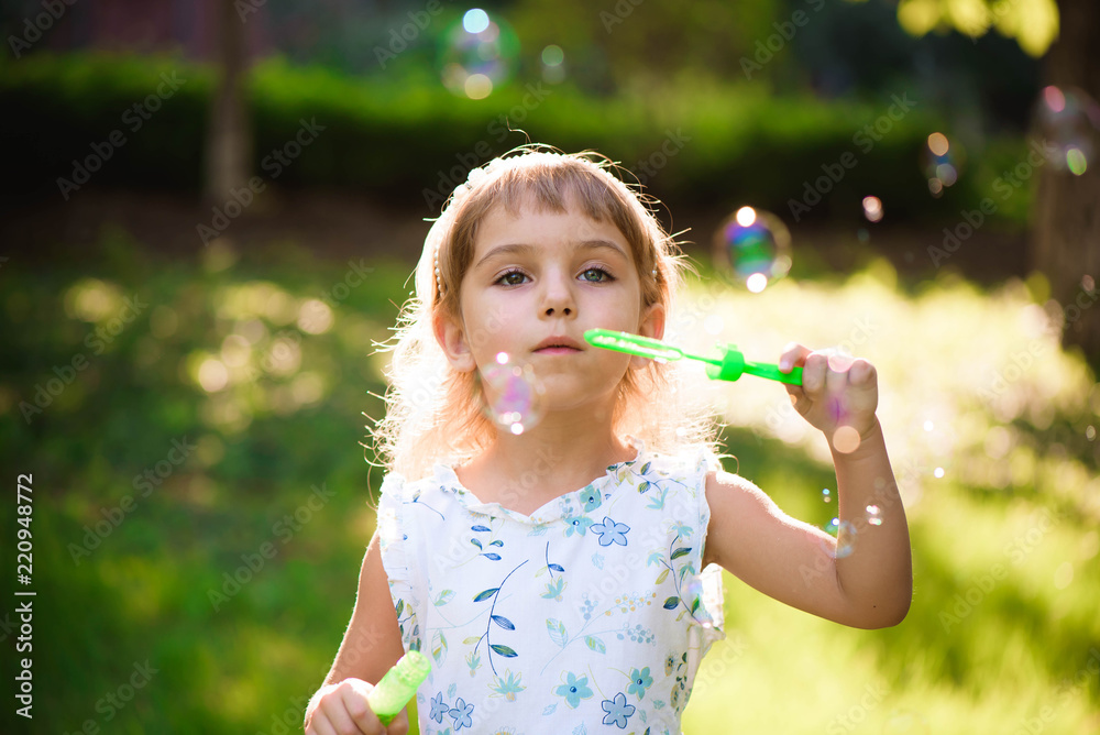 Girl with bubbles at a sunny summer evening