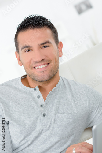 portrait of handsome young man smiling at home