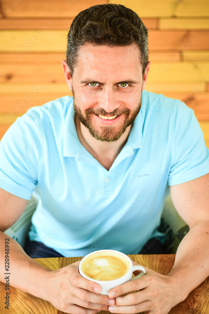 Caffeine can get creative juices flowing when you stuck in rut and it gives you drive. Cafe visitor happy face enjoy coffee caffeine drink. Man bearded guy drinks cappuccino at wooden table cafe Caffeine can get creative juices flowing when you stuck in rut and it gives you drive. Cafe visitor happy face enjoy coffee caffeine drink. Man bearded guy drinks cappuccino at wooden table cafe