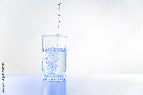 Glass of pure water on a white kitchen table