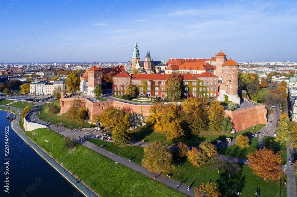 Krakow, Poland, with royal Wawel castle, cathedral and Vistula river in autumn. Aerial skyline panorama at sunset.