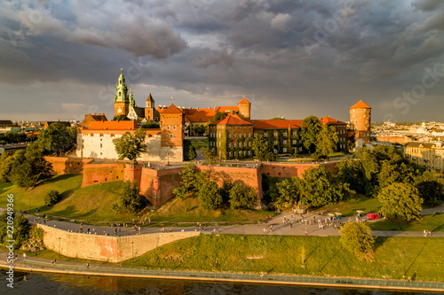 Historic royal Wawel castle and cathedral in Cracow, Poland. Aerial view in sunset light with dark stormy clouds