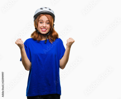 Young beautiful woman wearing cyclist helmet over isolated background celebrating surprised and amazed for success with arms raised and open eyes. Winner concept.