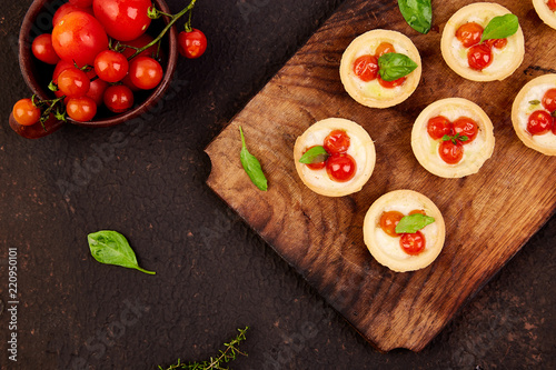 Mini tarts with cherry tomatoes with mozzarella cheese