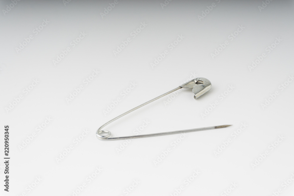 Safety pin isolated on a white background with selective focus and crop fragment Safety pin isolated on a white background with selective focus and crop fragment
