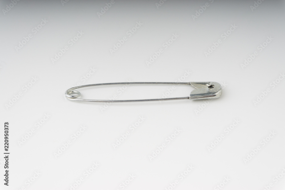 Safety pin isolated on a white background with selective focus and crop fragment Safety pin isolated on a white background with selective focus and crop fragment