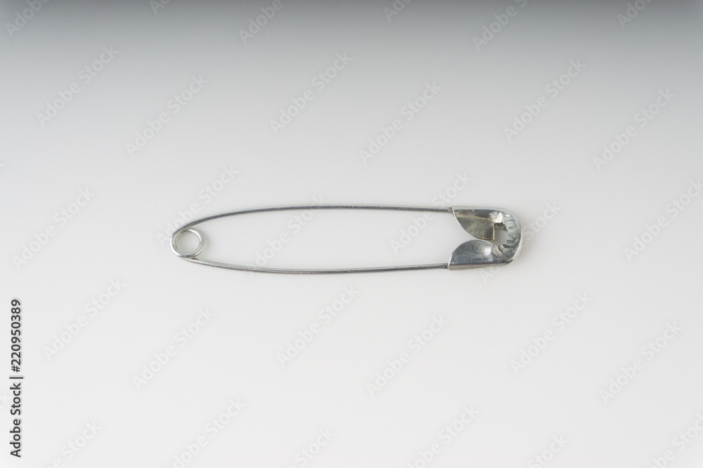 Safety pin isolated on a white background with selective focus and crop fragment Safety pin isolated on a white background with selective focus and crop fragment
