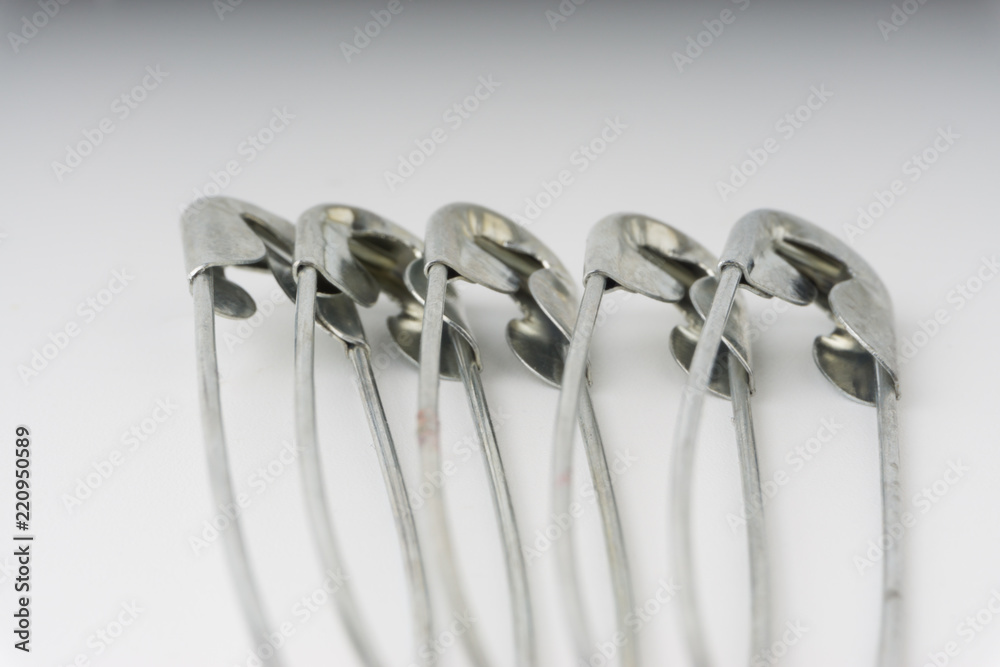 Safety pin isolated on a white background with selective focus and crop fragment Safety pin isolated on a white background with selective focus and crop fragment