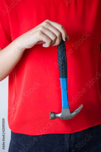 Woman holding the hammer in the hands photo