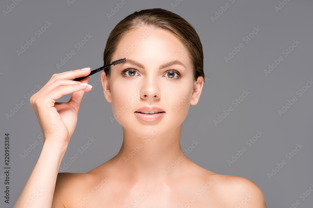 portrait of beautiful woman with makeup brush for eyebrows isolated on grey portrait of beautiful woman with makeup brush for eyebrows isolated on grey