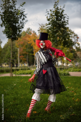 clown in red wig with in the park