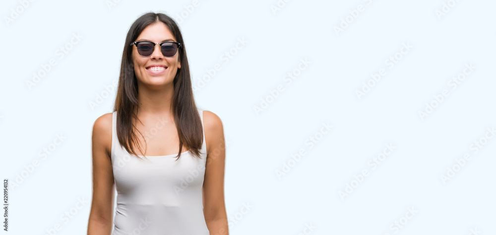 Young beautiful hispanic wearing sunglasses with a happy and cool smile on face. Lucky person.