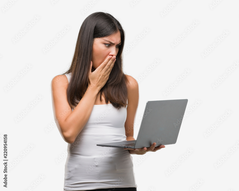 Young hispanic woman using computer laptop cover mouth with hand shocked with shame for mistake, expression of fear, scared in silence, secret concept Young hispanic woman using computer laptop cover mouth with hand shocked with shame for mistake, expression of fear, scared in silence, secret concept