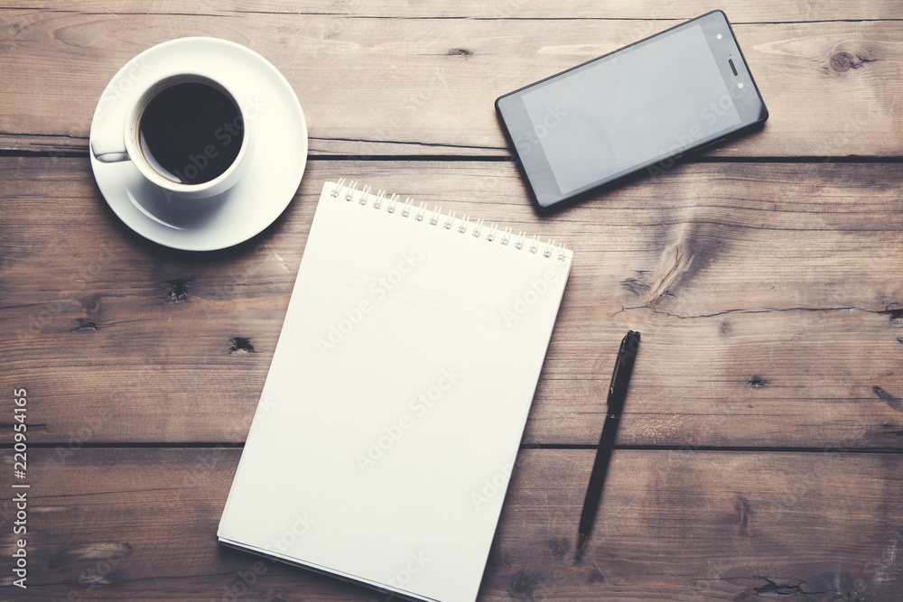 notepad with coffee and phone on table notepad with coffee and phone on table