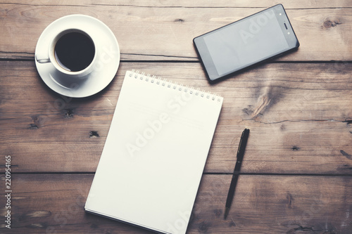 notepad with coffee and phone on table