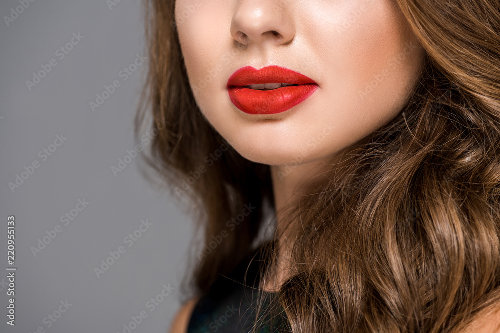 partial view of woman with applied red lipstick on lips isolated on grey partial view of woman with applied red lipstick on lips isolated on grey
