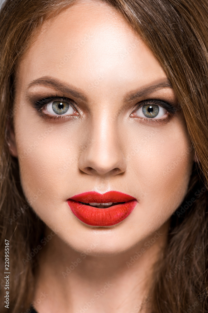 portrait of attractive young woman with red lipstick on lips looking at camera portrait of attractive young woman with red lipstick on lips looking at camera