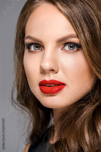 portrait of attractive young woman with red lipstick on lips looking at camera