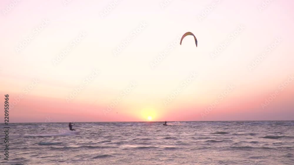 The man controls a training kite against the background of dawn The man controls a training kite against the background of dawn