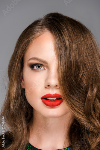 portrait of attractive young woman with red lipstick on lips looking at camera