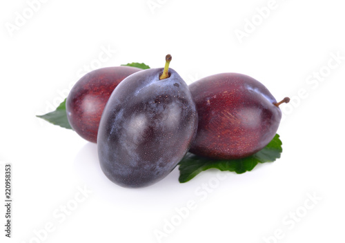 whole fresh prunes with leaf on white background