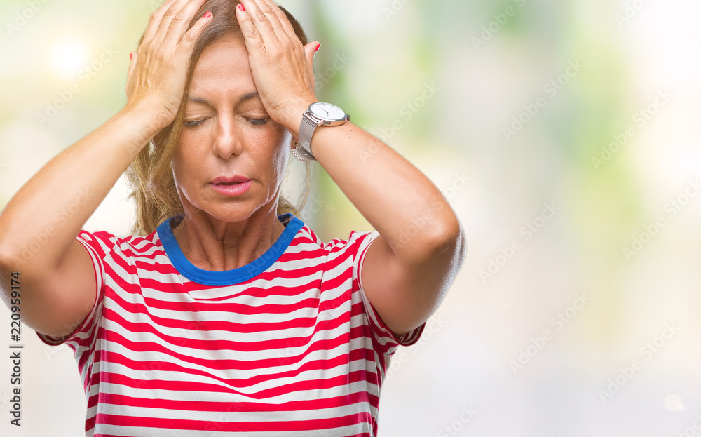 Middle age senior hispanic woman over isolated background suffering from headache desperate and stressed because pain and migraine. Hands on head.