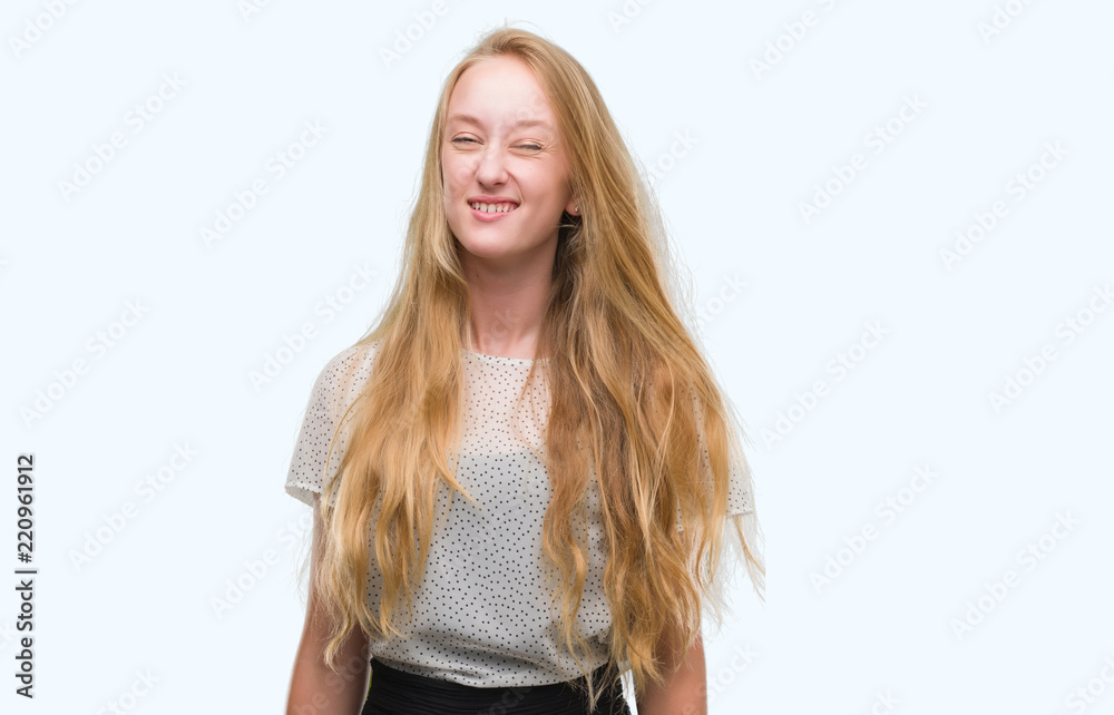 Blonde teenager woman wearing moles shirt winking looking at the camera with sexy expression, cheerful and happy face. Blonde teenager woman wearing moles shirt winking looking at the camera with sexy expression, cheerful and happy face.