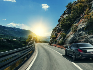 Fotobehang Snelle auto Zwarte auto raast over zonnige snelweg  © Denis Rozhnovsky