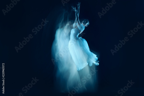 The photo as art - a sensual and emotional dance of beautiful ballerina through the veil on a dark background. A stroboscopic image of the one model