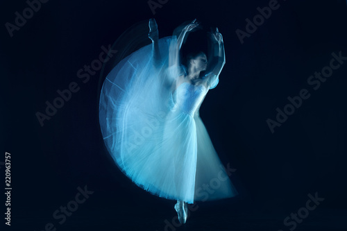 The photo as art - a sensual and emotional dance of beautiful ballerina through the veil on a dark background. A stroboscopic image of the one model photo