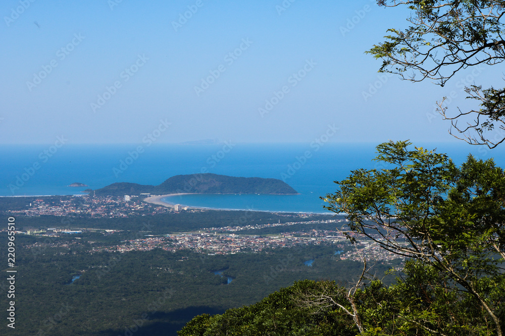 Beautiful panoramic view of green tropical forest, blue sky and beach of Bertioga city in the background - Atlantic Forest in Brazil Beautiful panoramic view of green tropical forest, blue sky and beach of Bertioga city in the background - Atlantic Forest in Brazil