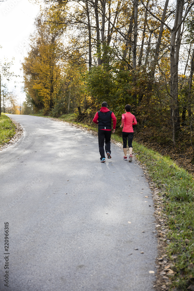 Young couple running on the sunny day in the autumn forest of the Bavarian National Park, Bavaria, Germany Young couple running on the sunny day in the autumn forest of the Bavarian National Park, Bavaria, Germany