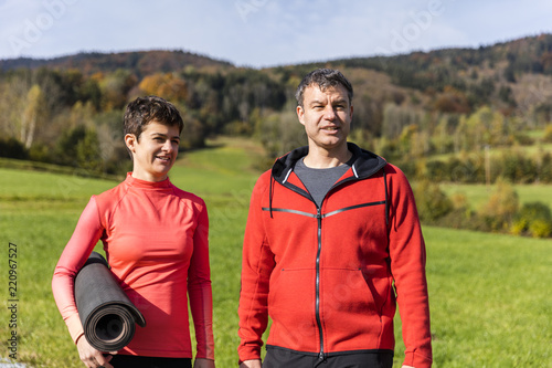 A couple set ready for outdoor exercises on a sunny autumn day in the countryside of Bavarian National Forest Park