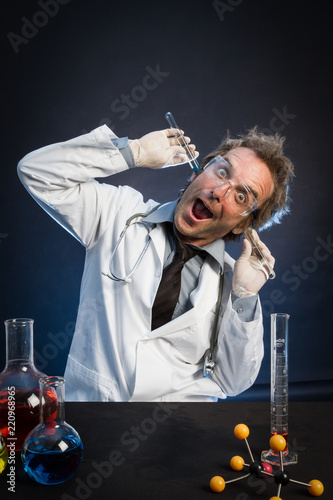 Mad Scientist, Wearing Protective Glasses, Holding Test Tubes in His Ears
