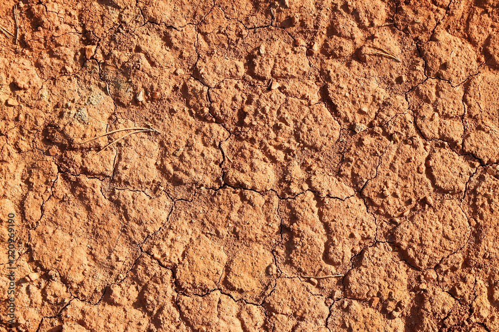 Dry polluted red stony soil, top view.