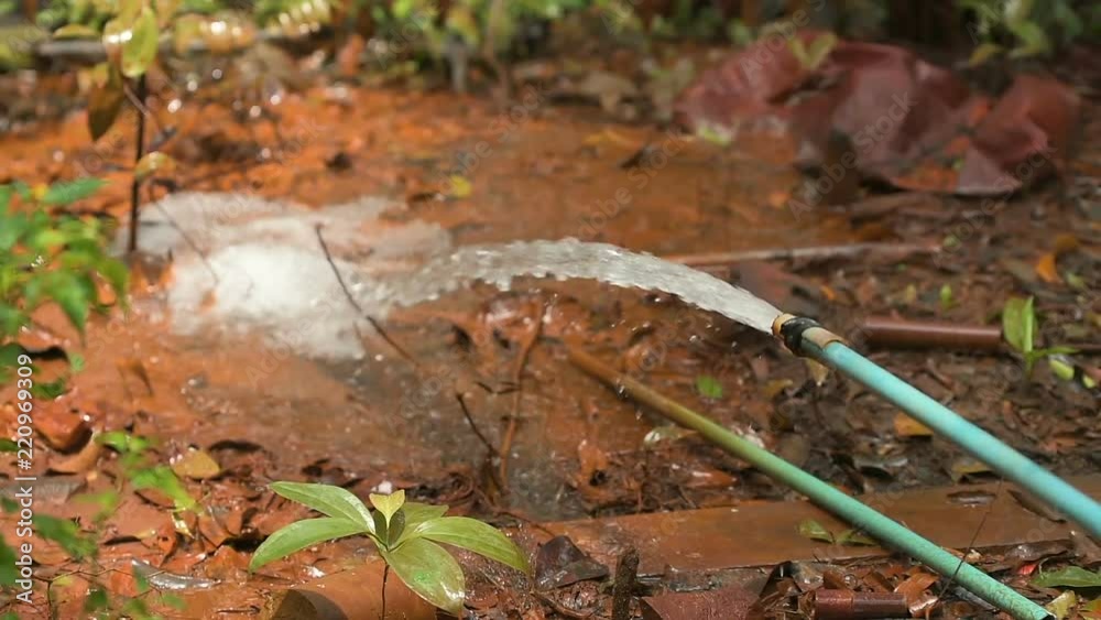 Clean water flowing from the hosepipe straight on the cambodian red ground. Clean water flowing from the hosepipe straight on the cambodian red ground.