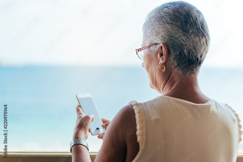 Elderly woman on the mobile phone at home