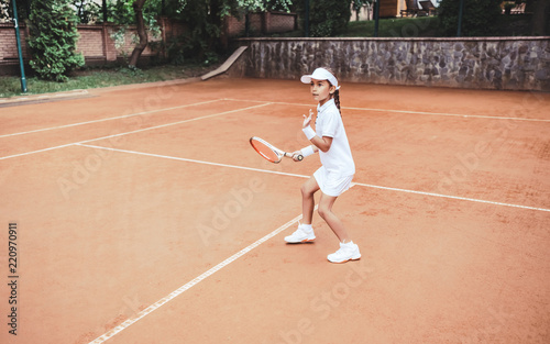 Young and beautiful tennis player in action on the court. © HBS